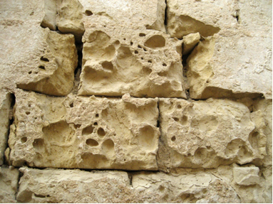 Antigo muro de pedra corroído pelo tempo e poluição de chuva ácida